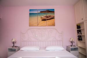 a bedroom with a bed and a picture of a beach at Petra Traditional House in Episkopión