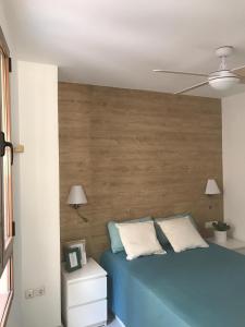 バレンシアにあるApartamento Joseph , luminoso, bonito y muy céntricoのベッドルーム1室(青いベッド1台、木製ヘッドボード付)