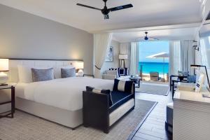 Fairmont Royal Pavilion Barbados Resort في سانت جيمس: غرفة نوم بسرير كبير ومطلة على المحيط