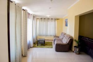ein Wohnzimmer mit einem Sofa und einem Stuhl in der Unterkunft Lynm Residence in Harare