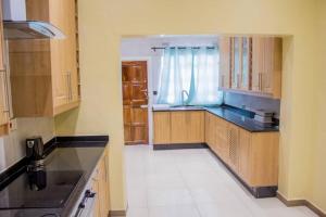 a kitchen with wooden cabinets and black counter tops at Lynm Residence in Harare