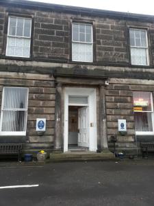 a brick building with a white door and a black door at Counan Guest House in Edinburgh