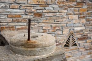 a brick wall with a statue of a bell at Petra Traditional House in Episkopión