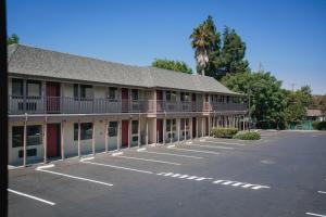 a building with a parking lot in front of it at Alura Inn in San Jose