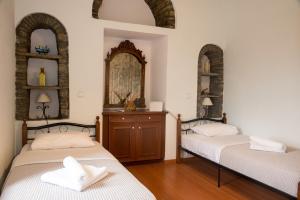 two beds in a room with two mirrors at Petra Traditional House in Episkopión