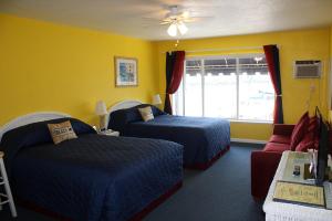 
a hotel room with two beds and two windows at Barefoot Bay Resort Motel in Clearwater Beach
