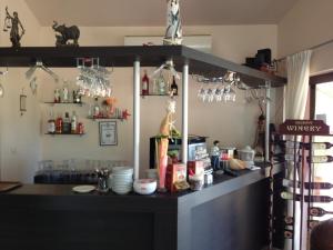 a bar in a restaurant with a counter and shelves at Семеен хотел Катерини in Sinemorets
