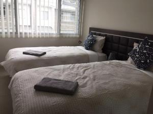 戈斯福德的住宿－Gosford Townhouse，卧室内的两张床和毛巾