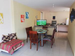 ein Wohnzimmer mit einem Tisch, Stühlen und einem TV in der Unterkunft Dulce Hogar in Loja