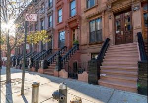 a fire hydrant in front of a building with stairs at Spacious Fully Furnished Harlem Apartment Near Morningside Park in New York