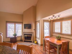 a dining room with a table and a fireplace at Spacious 2 Bed Condo at Crystal Mountain Resort in Thompsonville