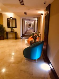 a hallway with a blue couch in a hotel room at Waldorf Hotel in Caracas +56 photos