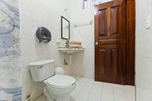 a bathroom with a toilet and a wooden door at Casa Palma Hotel in Playa del Carmen