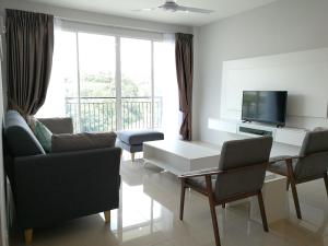a living room with a table and chairs and a television at Omni Cassia Hill Resort in Cameron Highlands