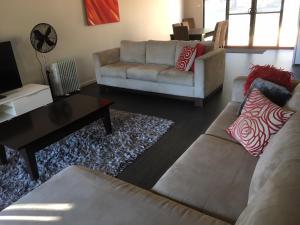 uma sala de estar com um sofá e uma mesa de centro em Hunter Valley Retreat em Quorrobolong