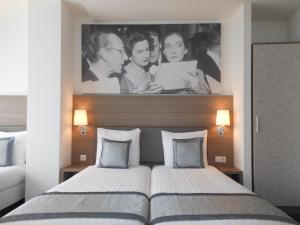 una camera con un letto con una foto sul muro di The Concert Hotel ad Amsterdam