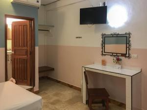 a room with a desk and a mirror on the wall at Casa Palma Hotel in Playa del Carmen