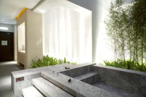 una panchina di cemento in una stanza con piante di I DO Motel a Taoyuan