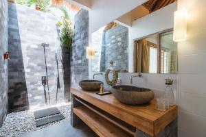 a bathroom with two vessel sinks on a wooden counter at Balidroomvilla's in Candidasa +61 photos