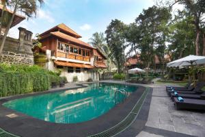 a swimming pool in front of a house at Champlung Sari Hotel and Spa Ubud in Ubud