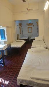 a room with four beds and a desk in it at Kanha Paying Guest House in Varanasi