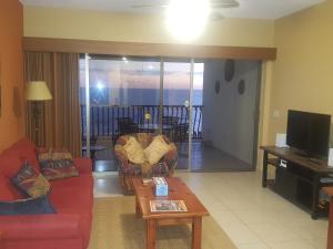 Sonoran Sun Resort في بورتو بيناسكو: غرفة معيشة مع أريكة وطاولة قهوة