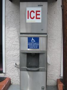 una máquina de hielo sentada fuera de un edificio en Walls Motel Long Beach en Long Beach