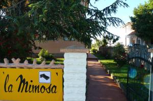 a sign on a fence in front of a house at La Mimosa in Bolgheri