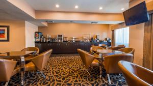 a hotel room with tables and chairs and a bar at Best Western Plus - Wendover Inn in Wendover