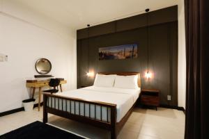 a bedroom with a large bed with a black headboard at Neveu Premier Residence : Ratchada in Bangkok