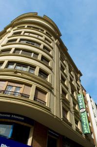 um edifício alto com uma placa de rua em frente em Hotel Castilla em Gijón