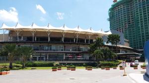 a large building with a white roof in a parking lot at Prime Sea View Condo in Davao in Davao City