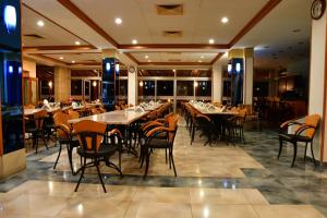 a dining room with tables and chairs in it at Tylos Beach Hotel in Kato Pyrgos