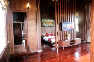 ein Schlafzimmer mit einem Bett mit roten Kissen darauf in der Unterkunft THƯ DUY Resort in Cà Mau