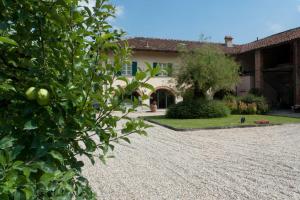 a house with a gravel driveway in front of it at La Giribaldina Winery & Farmhouse in Calamandrana