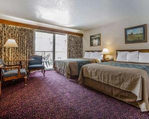 a hotel room with two beds and a desk and a window at Econo Lodge Near Reno-Sparks Convention Center in Reno