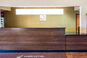 a lobby with a wooden counter with a welcome sign at Sleep Inn & Suites Oregon in Oregon