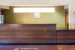 una hall con bancone in legno e cartello di benvenuto di Sleep Inn & Suites Oregon a Oregon