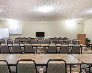 a large room with tables and chairs and a screen at Quality Inn & Suites in Rosemount