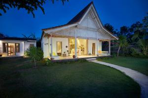 a white house with a gambrel roof at Villa Coral in Pemuteran