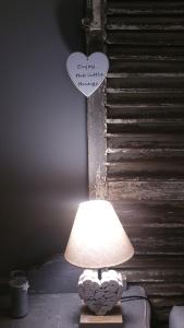 une lampe assise sur une table avec un cœur sur le mur dans l'établissement La Bastide des Songes - Demeure d'hôtes, à Robion