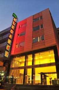 a building with a neon sign in front of it at Hotel Elegance in New Delhi