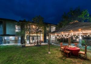 a patio with a table and chairs in front of a house at SaffronStays Falcon Hill, Lonavala - luxury villa with infinity pool near Lion's Point in Lonavala