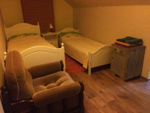 een slaapkamer met 2 bedden, een stoel en een tafel bij Kuldkaru Manor in Valaste