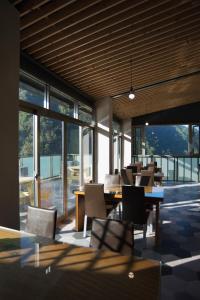 a dining room with tables and chairs and windows at Tang Zhimei Hot Spring in Taian