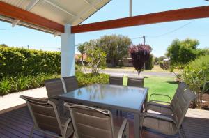 a patio with a table and chairs on a deck at Beechtree in Dunsborough
