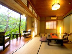 a room with a table and chairs and a large window at Midoriso in Hioki