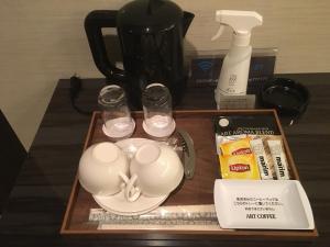 N hotel #NL1 في شيبا: صينية مع كوبين ومجموعة شاي على طاولة
