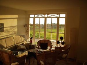 a living room with a couch and a table and a window at Haus am Achterwasser Whg "Kapitän Nemo" in Ueckeritz