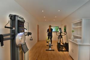 a woman riding a exercise bike in a room at Hôtel Escale Oceania Lorient in Lorient